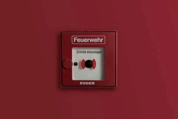 Fire alarm switch with "Feuerwehr" label for emergency fire alert.