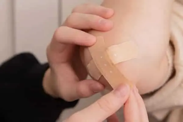 Person applying a bandage to their arm during training or injury recovery.